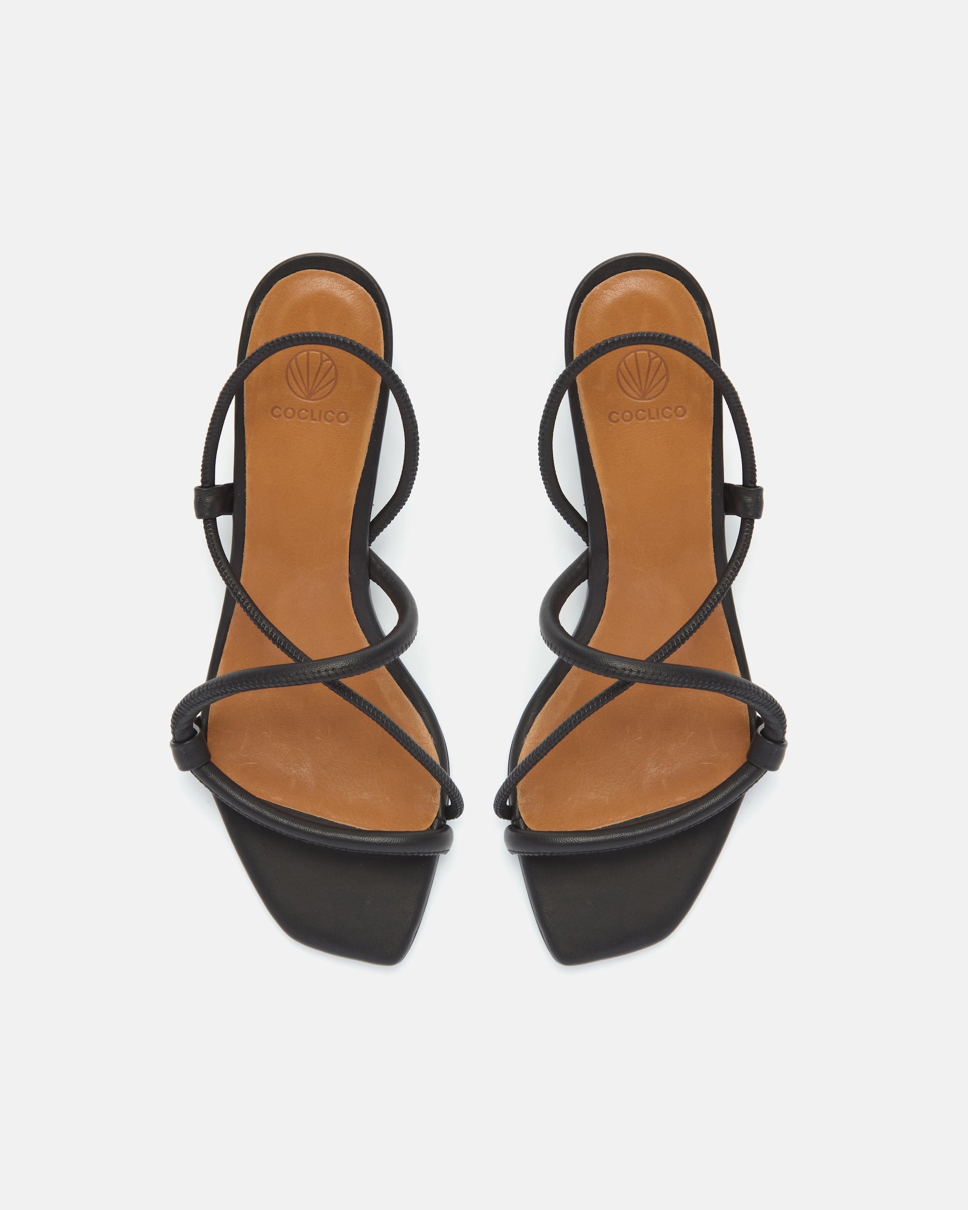 Top view of a black leather mid-heel sandal with slim straps, elasticized slingback, and a graceful demi heel