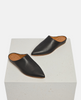Pair of black leather slippers on a white cube 4