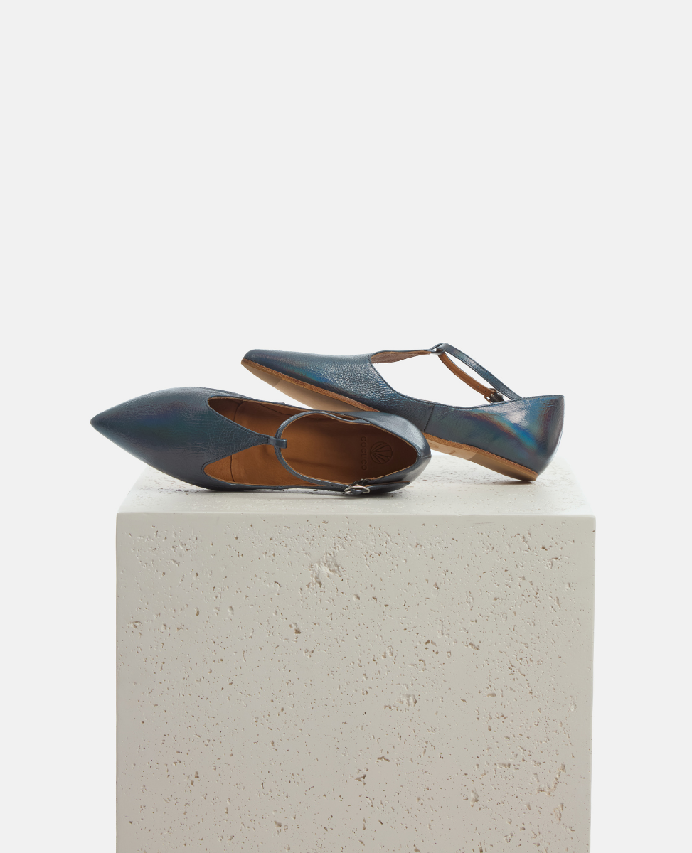 Pair of blue shoes on a white pedestal against a white background