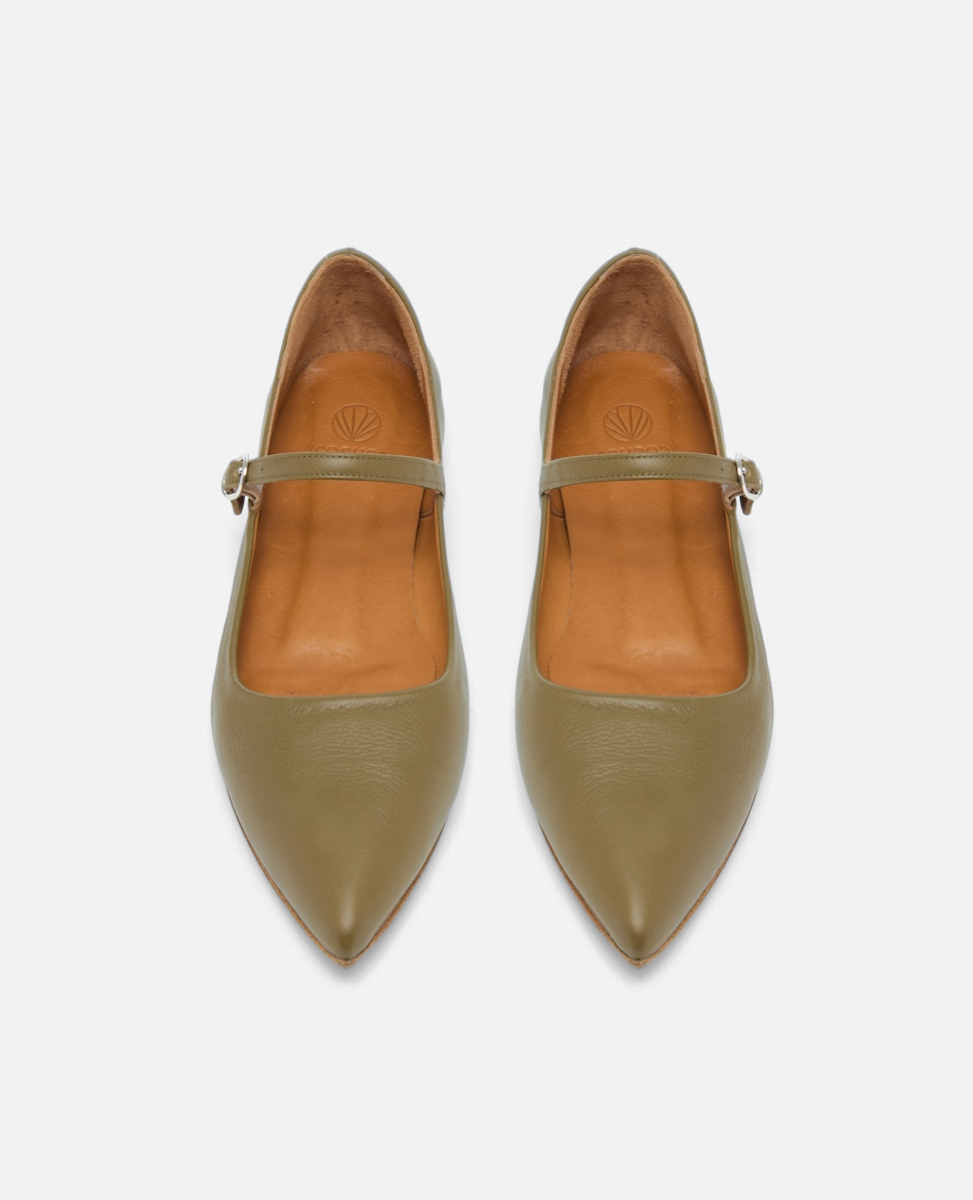 Pair of green pointed-toe shoes with tan interior on a white background