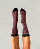 Pink and black striped socks on a plain background 2