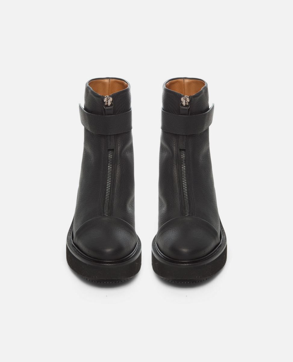 Pair of black leather boots with zipper details on a white background