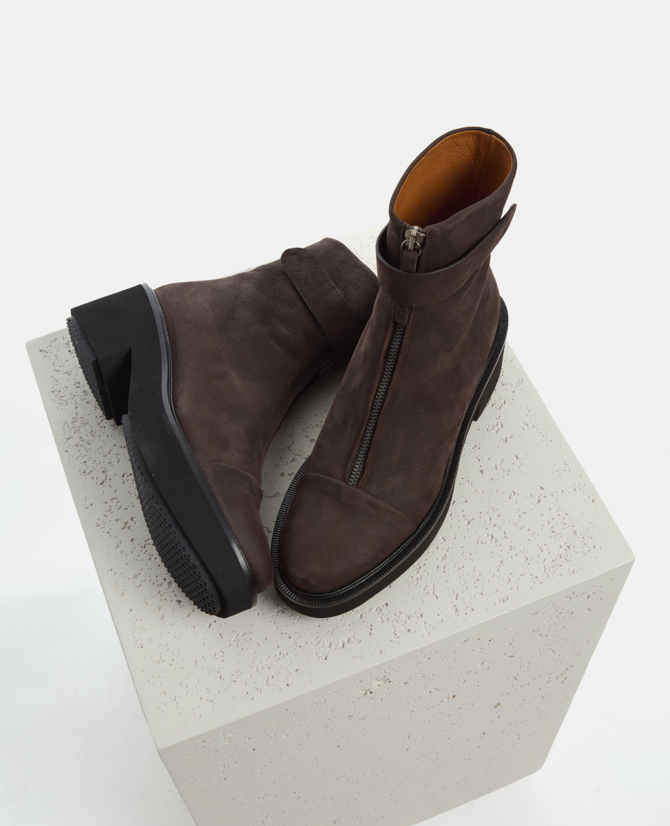 Pair of brown leather boots on a textured white platform