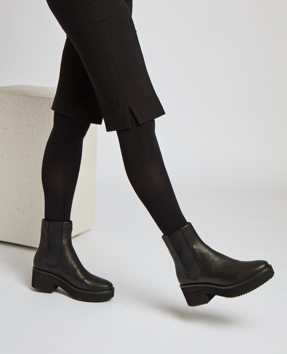 Sleek black ankle boots with a smooth leather finish, featuring elastic side panels, a low block heel, and a slightly rounded toe.