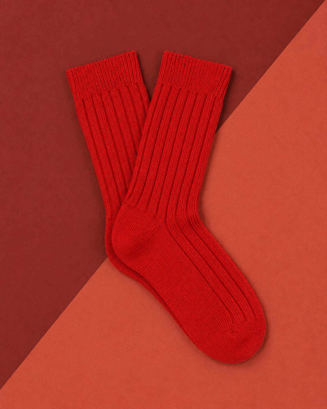 Escuyer women's cashmere crew socks in red on a two-tone red background