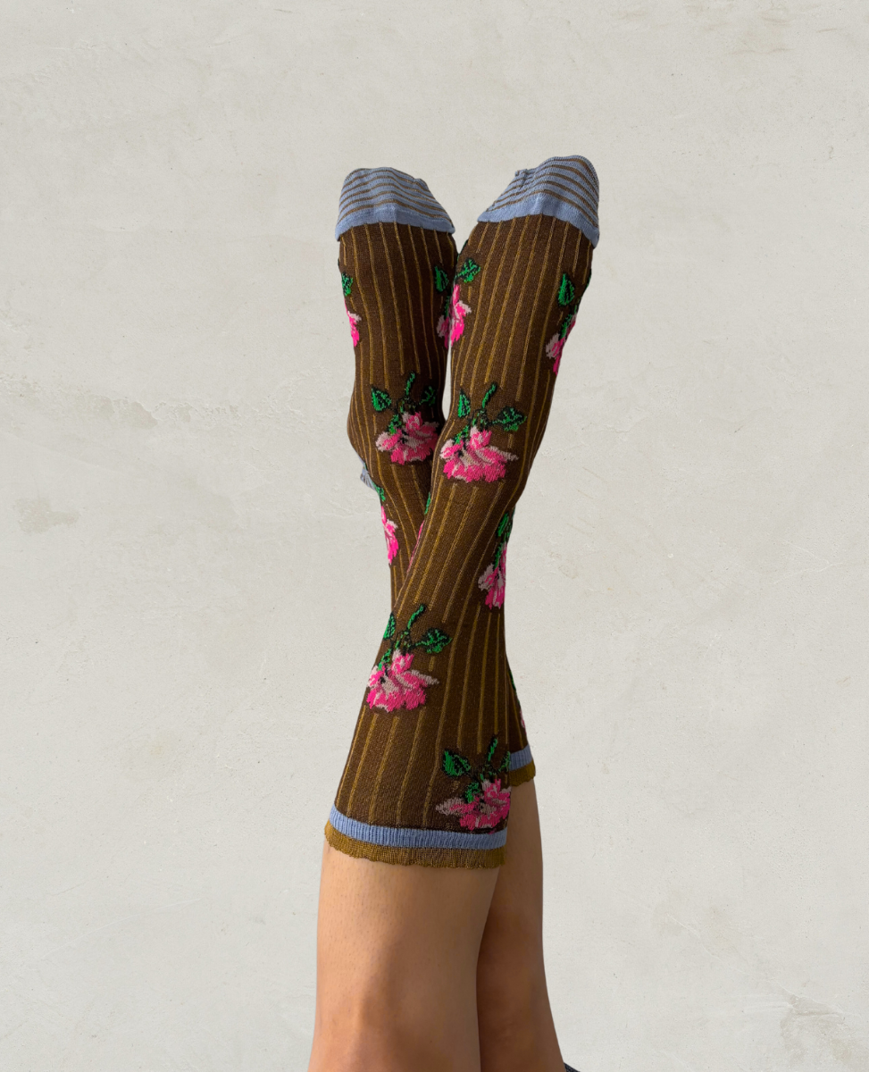 Exquisite J Brown striped socks with floral patterns worn by a person on a light gray background