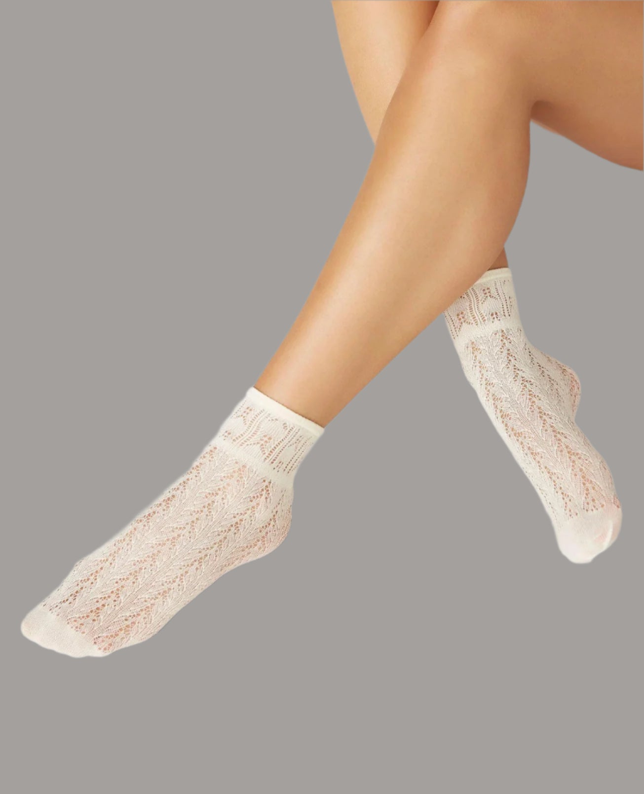 Cream-colored ankle socks with a delicate lace pattern, featuring a soft, stretchy texture and a snug fit around the ankles.