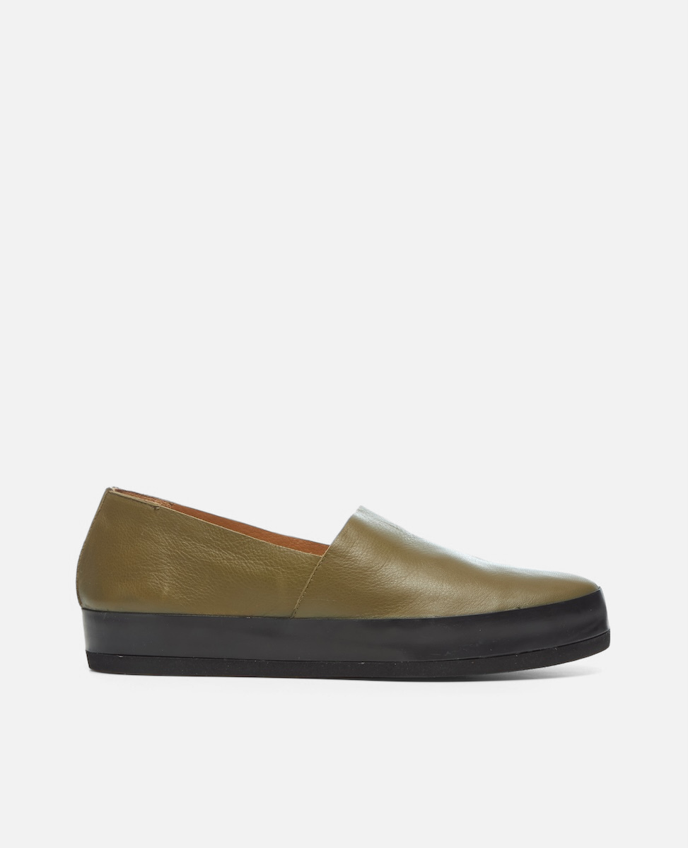 Green slip-on shoe with black sole on a white background