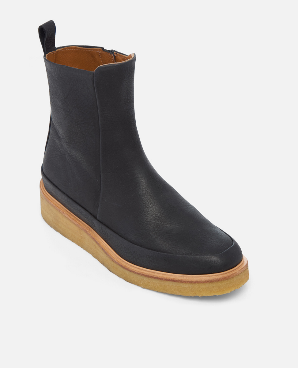 Black ankle boot with brown sole on a white background