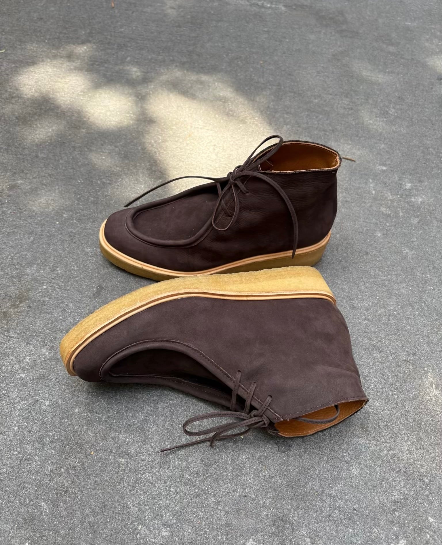 Pair of brown suede CHUKKA BOOTS with CREPE soles on a gray pavement.