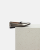Silver loafer shoe on a light gray surface with a white background 4