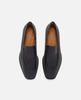 Pair of black loafers with tan interior on a white background 1