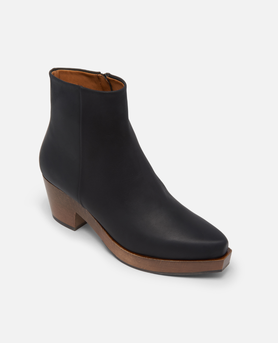 Black ankle boot with brown sole on a white background
