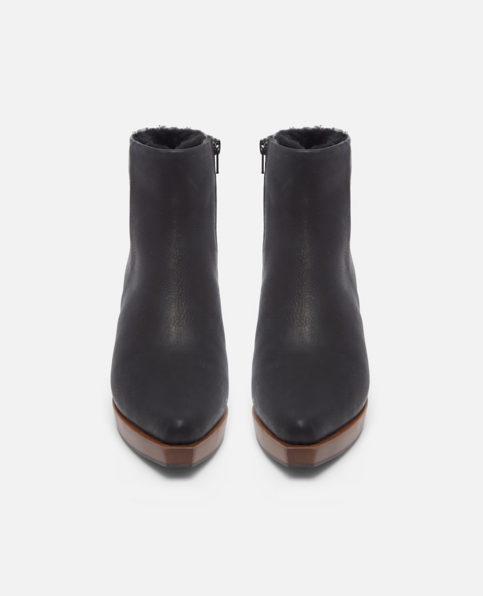 Pair of black ankle boots with brown soles on a white background