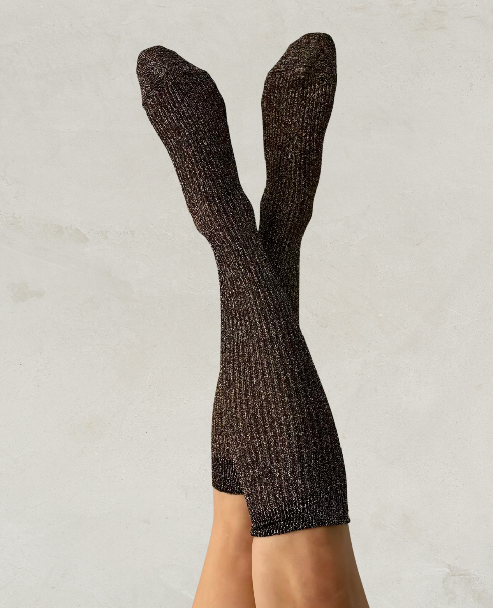Brown glitter knee-high socks worn by a person on a light gray background