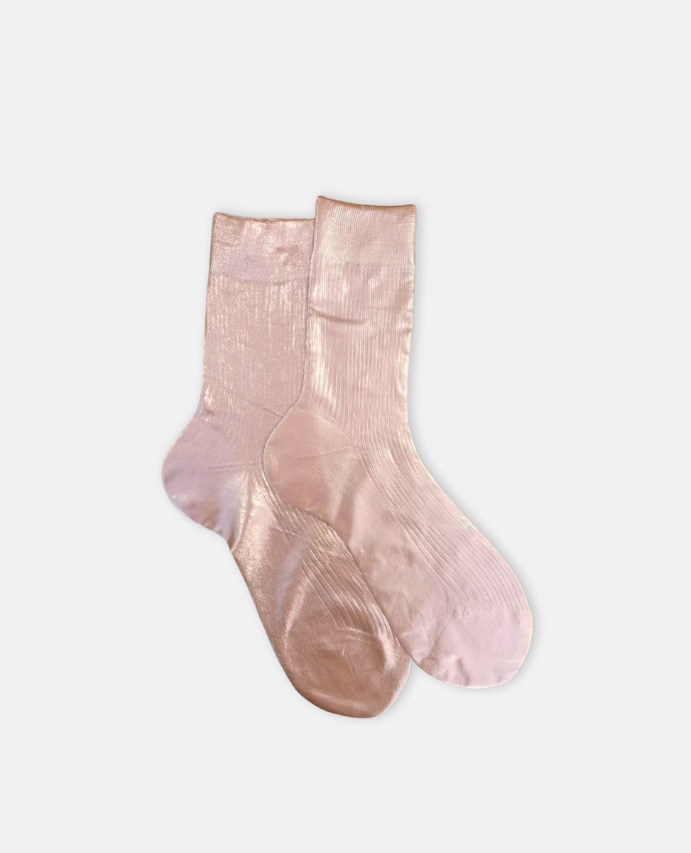 Pair of metallic foil pale pink silk socks by Maria La Rosa on a light gray background