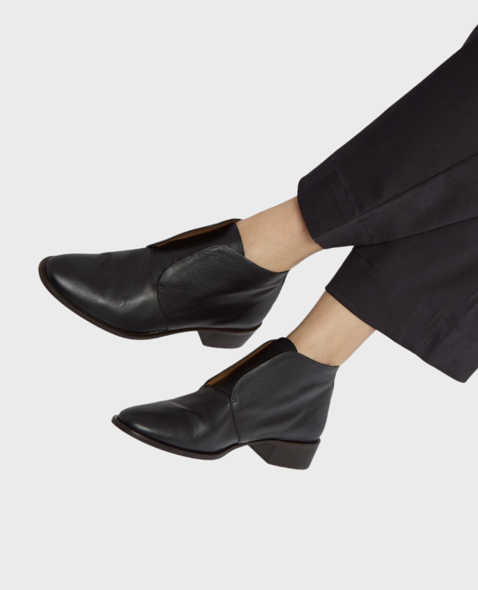 Sleek black leather ankle boots with a rounded toe, low leather stacked heel, easy slip-on wear.