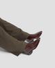 Brown pants and burgundy shoes on a light gray background 5