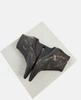 Black marble sculpture on a textured white platform 5