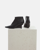 Black ankle boots on a light gray pedestal against a white background 3