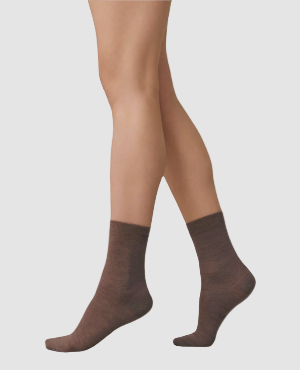 A pair of brown, mid-calf socks with a smooth texture, snug fit, and subtle ribbing at the top.