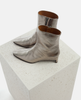 Pair of silver ankle boots on a textured white platform 5