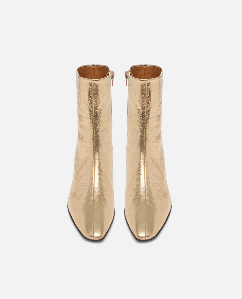 Pair of gold ankle boots on a white background