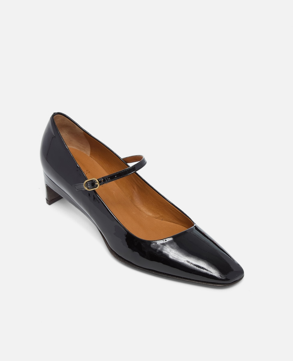 Black patent leather shoe with a strap on a white background
