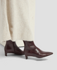 Brown leather ankle boots worn with a cream sweater on a light gray background 7