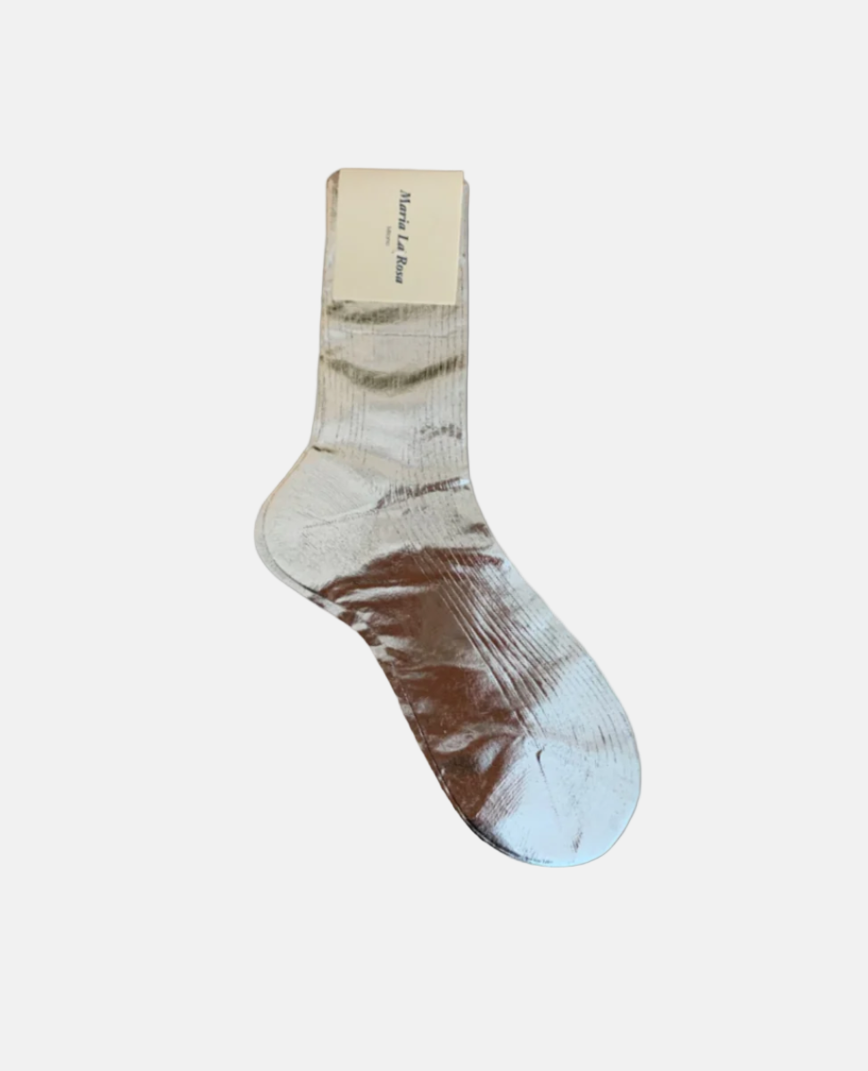 A single, metallic silver sock with a ribbed texture, mid-calf length, and a beige label attached near the top.