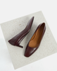 Pair of brown high-heeled shoes on a textured white platform 6