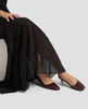 Person wearing dark brown shoes and black pants on a light gray background 5
