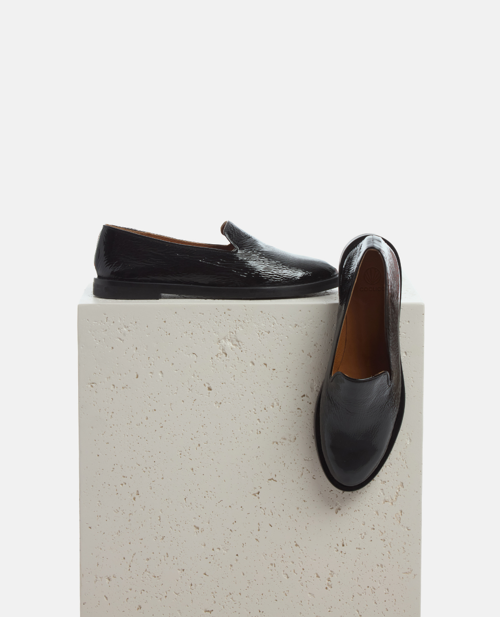 Black leather shoes on a textured white platform