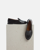 Black leather shoes on a textured white platform 4