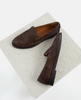 Pair of brown loafers on a textured white platform 5