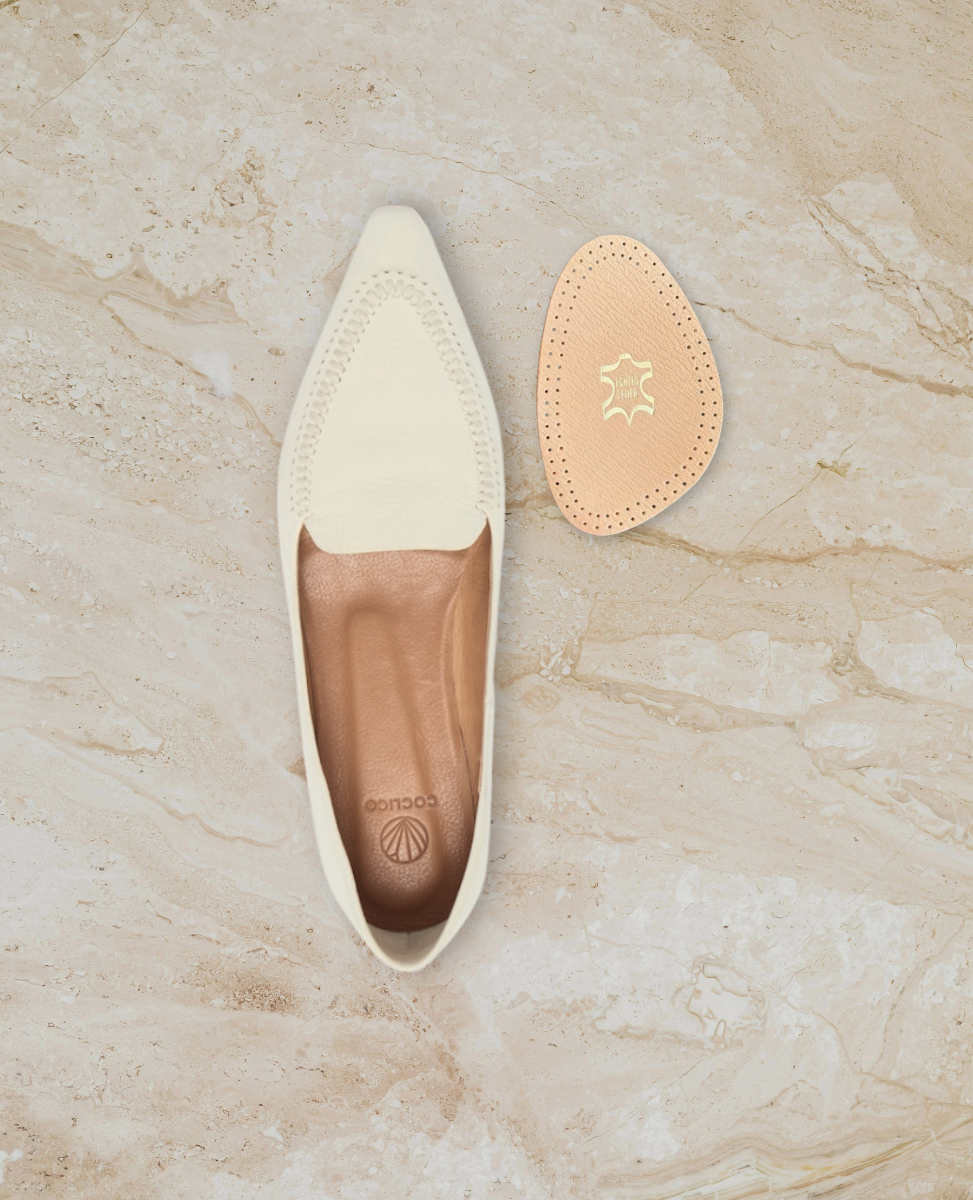 White loafer and half foot pad on stone surface