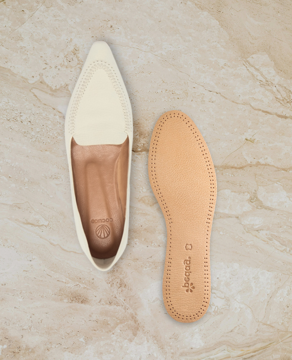 White loafer and leather insole on stone