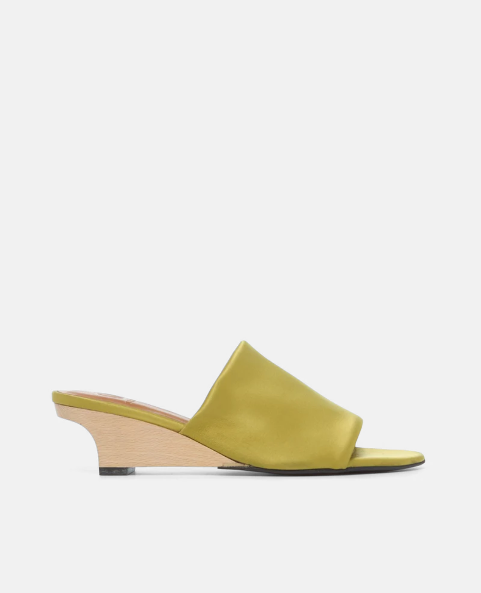 A satin olive green slide sandal featuring an open toe design and a low, light wooden block heel.