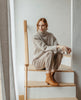 Woman sitting on steps wearing Coclico Caviar Boot in Mandorla leather. 3