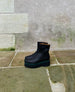 Coclico Charme Boot in Black leather - on stone flooring, side view.  8