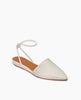A stylish, white, pointed-toe flat shoe with a perforated design and an ankle strap. 3