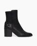 Side view of Coclico Babette Boot in Black leather: block-heeled, round-toe boot with half belt and loop detail adorn the heel. 1