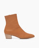 Side view of the Coclico Caviar Boot in Mandorla leather: a simple, modern boot with a low-height wood block heel, inside zip closure and tall shaft height. 1