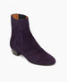 The Celeste Boot in amethyst suede: a sleek, mid-heel Chelsea boot with leather-covered gore. Angled view.  2