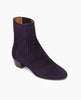 The Celeste Boot in amethyst suede: a sleek, mid-heel Chelsea boot with leather-covered gore. Angled view. 2