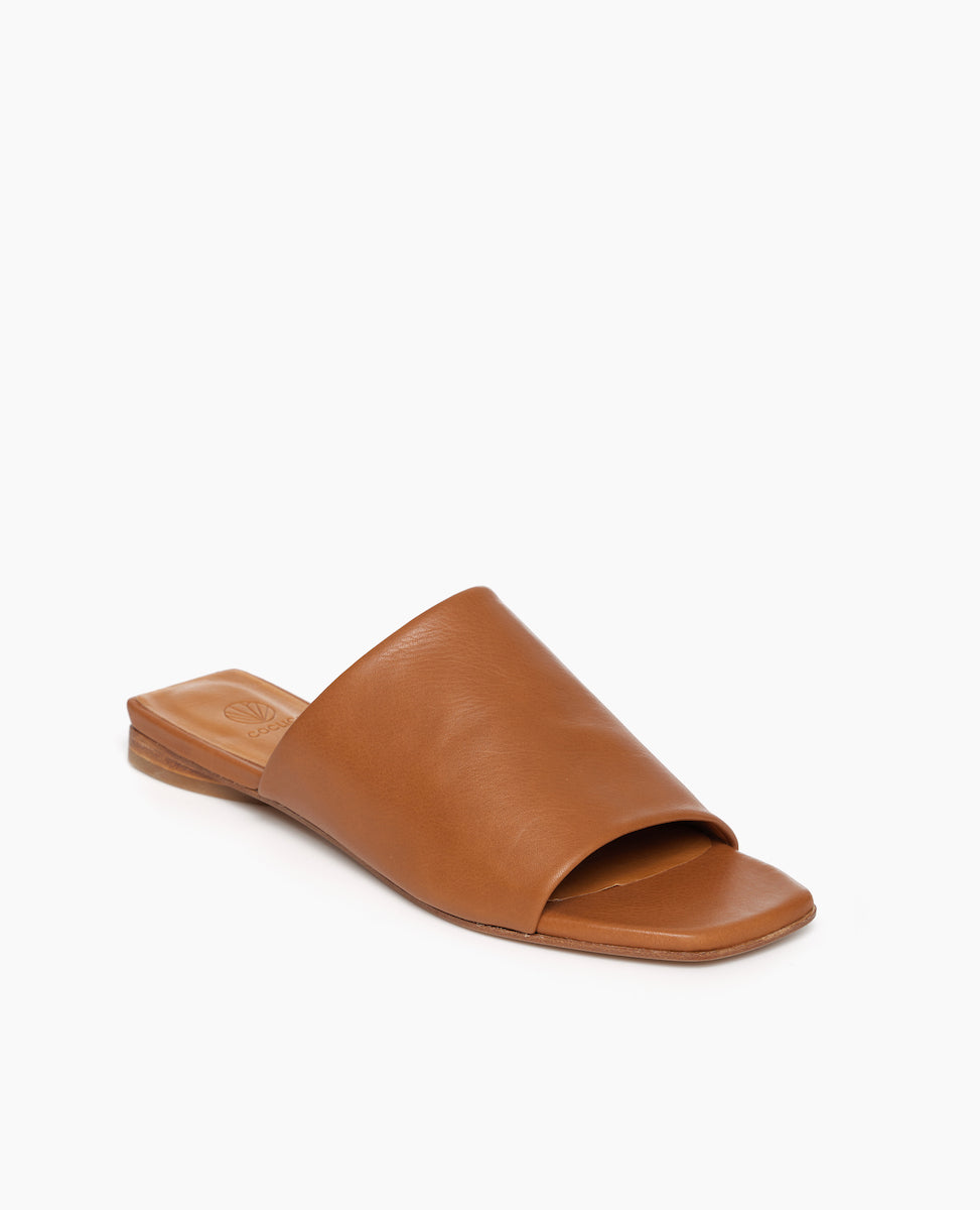 Coclico Ferhana Sandal in Cuoio leather, angled view: flat slide-on style with one solid band of leather, squared-off at the toe and heel.