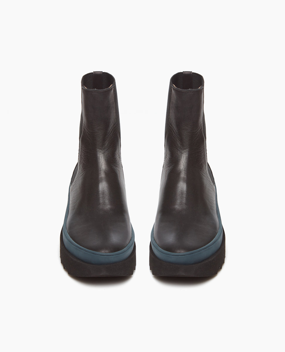 Front view of the France in Black leather an easy pull-on chelsea boot with rubber midsole in teal, and toothed EVA out sole in black.