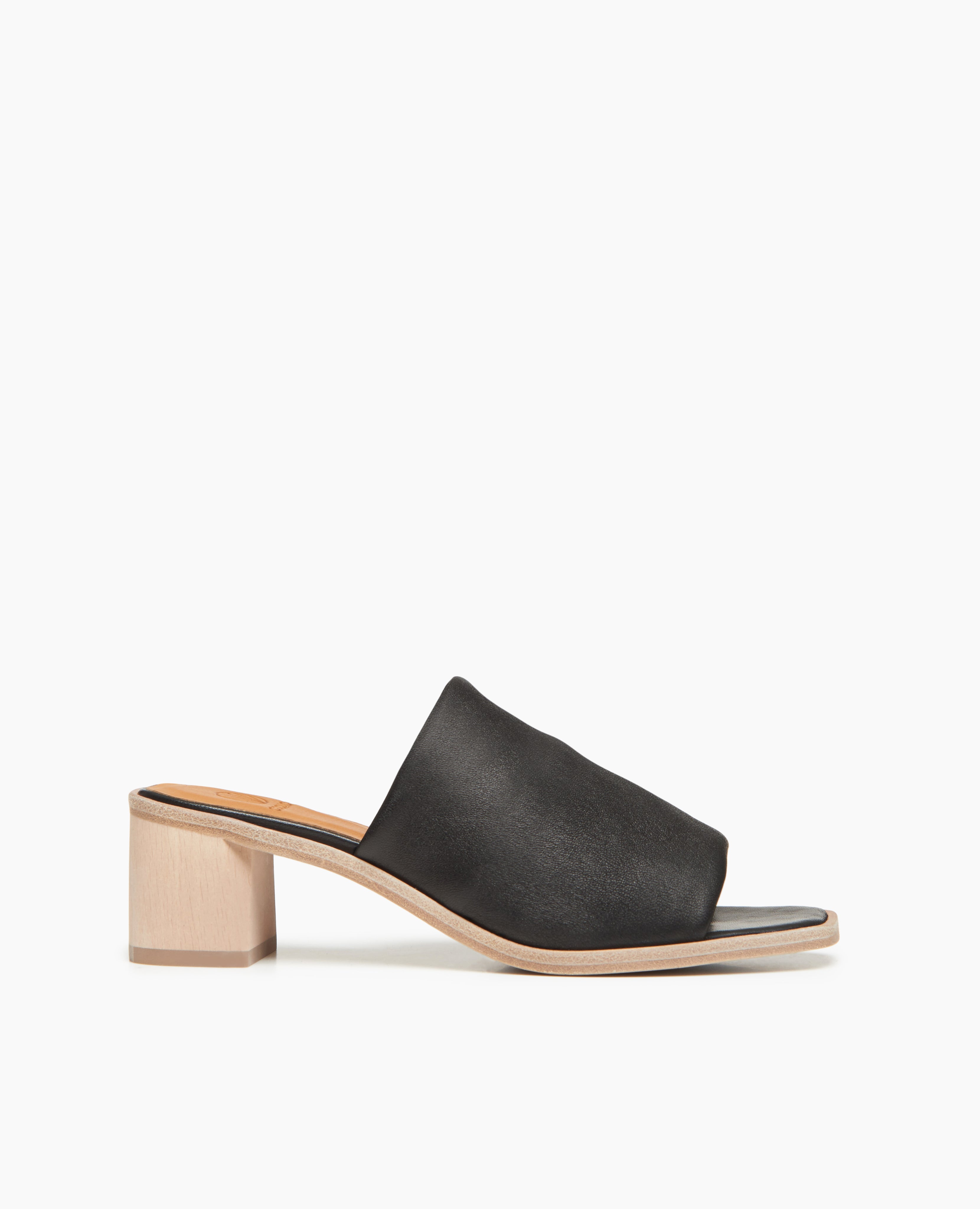 Side view of Coclico Jacque Heel in Black leather: slide-on style with a stretch leather band across foot and a wood block mid-height heel.