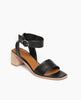 Angle view: Coclico Jagua Heel in Black leather a mid-height block wood heel with a leather strap across foot, ankle strap, buckle closure. 2