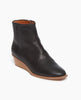 Angled view of the Java Boot in Black: featuring a solid wood low wedge with a slightly higher shaft and clean lines. Inside zip closure. 2
